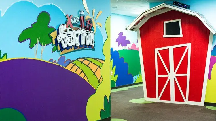 Painted red barn and rolling hills mural inside a commercial space